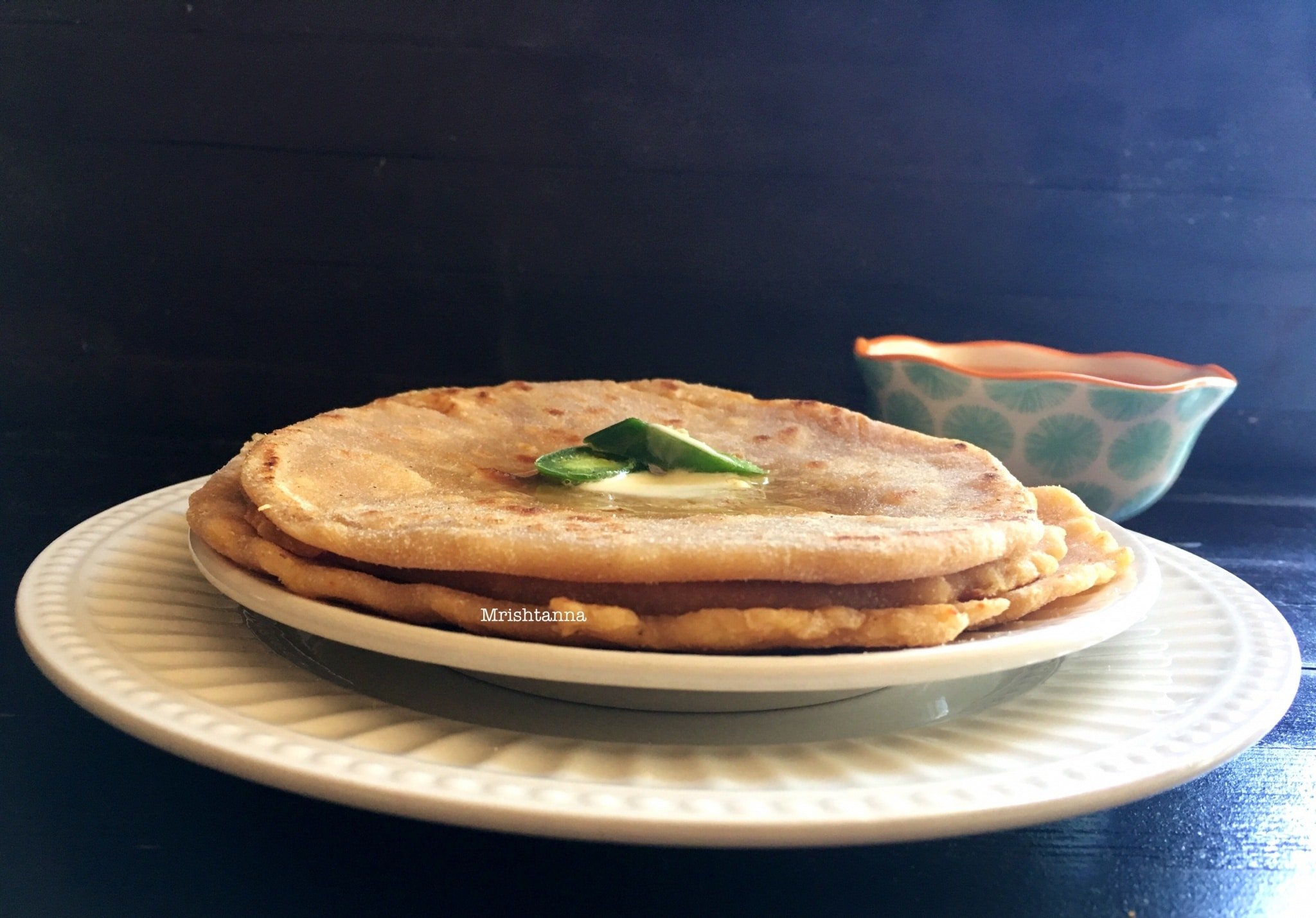 Sweet potato paratha is sitting on top of a plate on a table