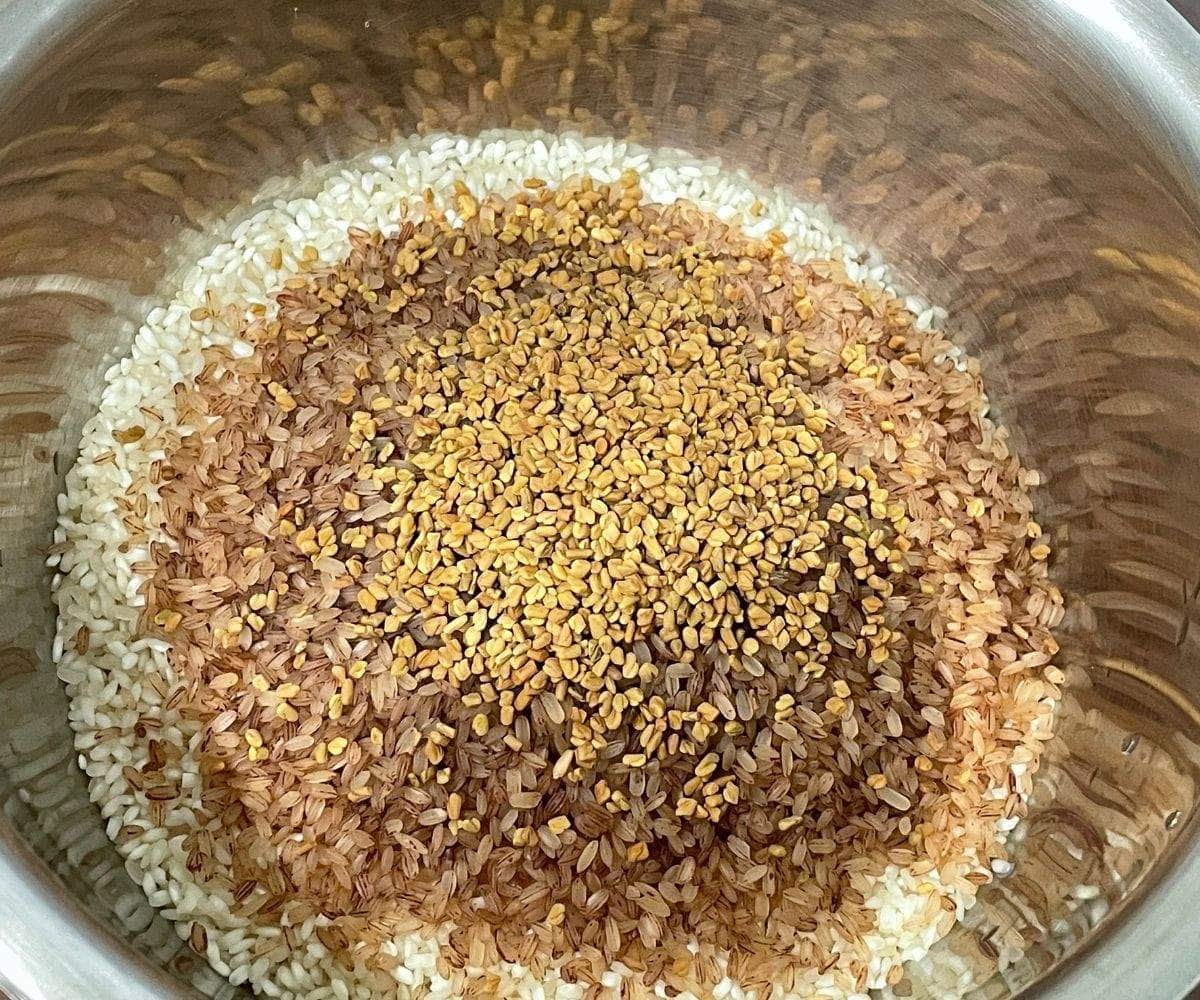 A bowl is with rice, brown rice, and fenugreek seeds