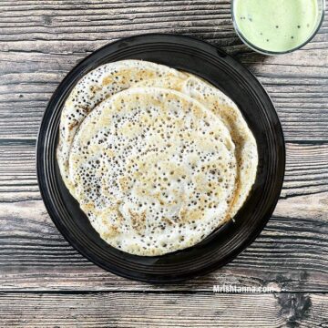 A plate is with methi dosa and chutney on the table