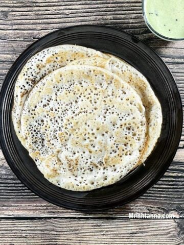 A plate is with methi dosa and chutney on the table