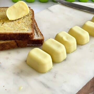 A tray is with vegan butter cubes and toasted bread by the side.