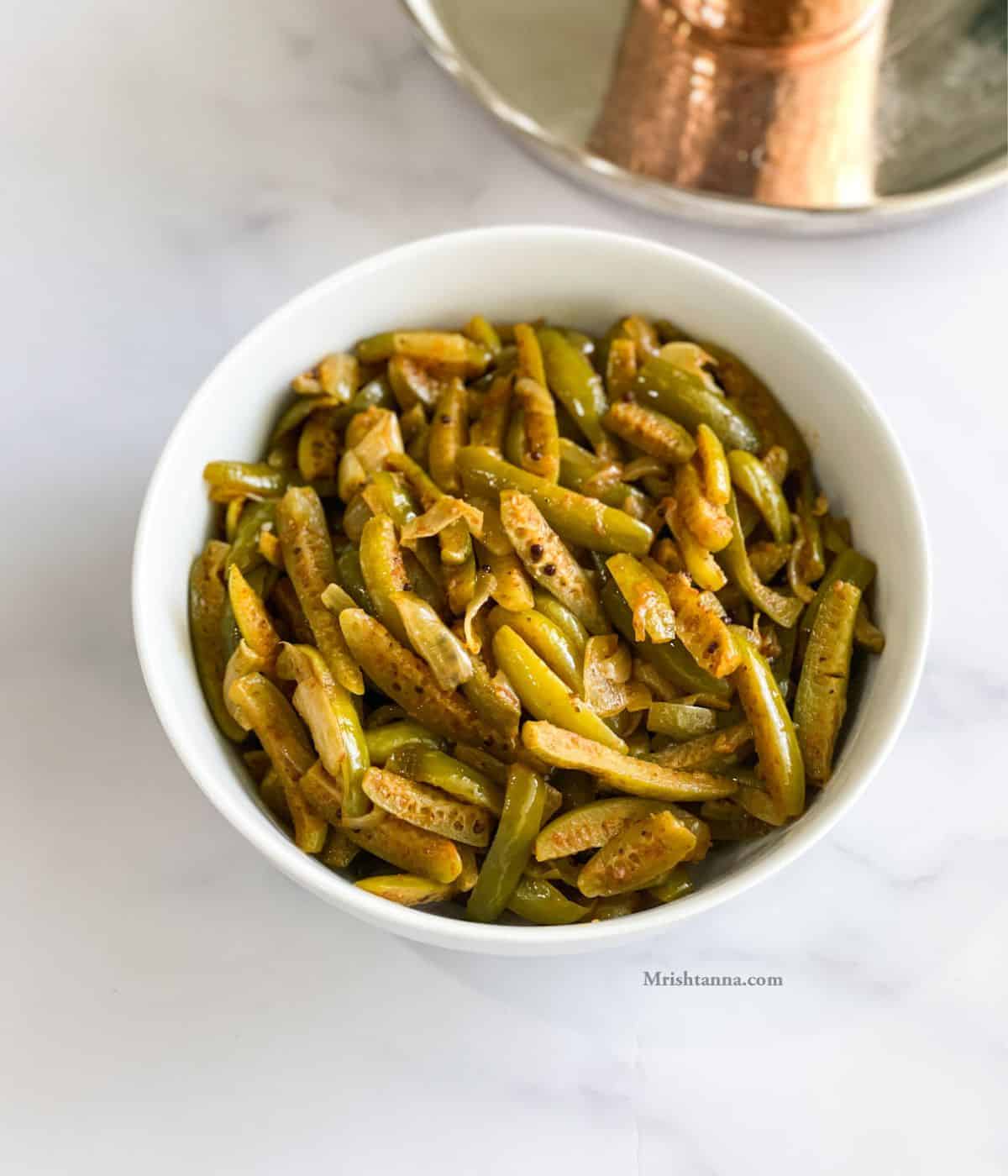 A bowl of ivy gourd fry is on the table.