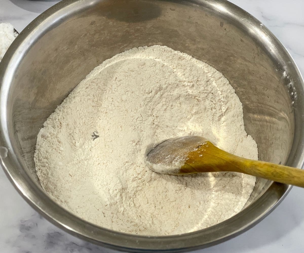 A large bowl is with dry ingredients like flour, salt and baking soda.