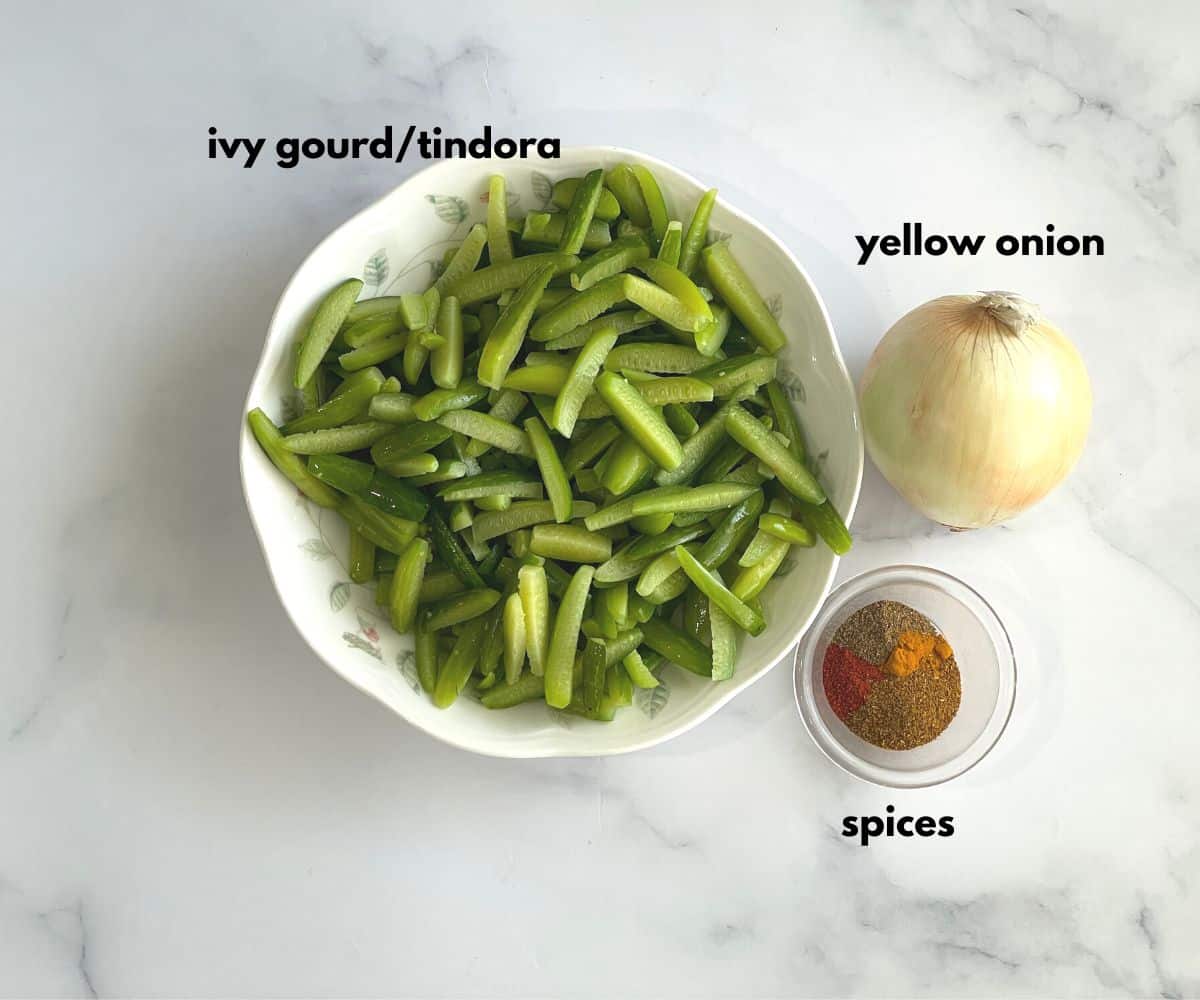 A table is with tindora fry ingredients.