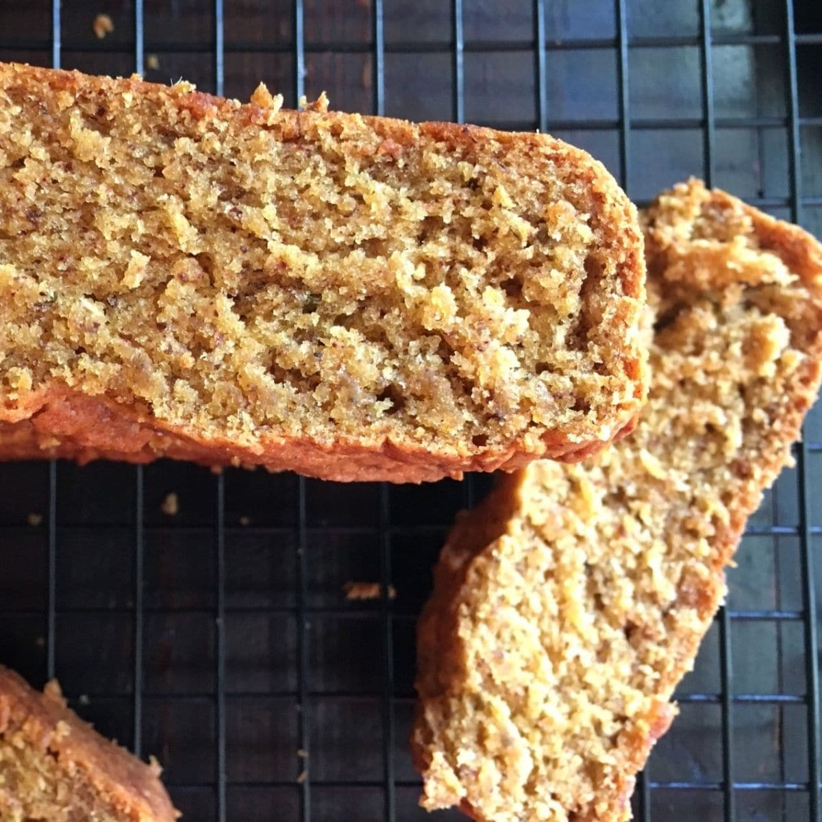 A sliced mango bread is on the wire rack.