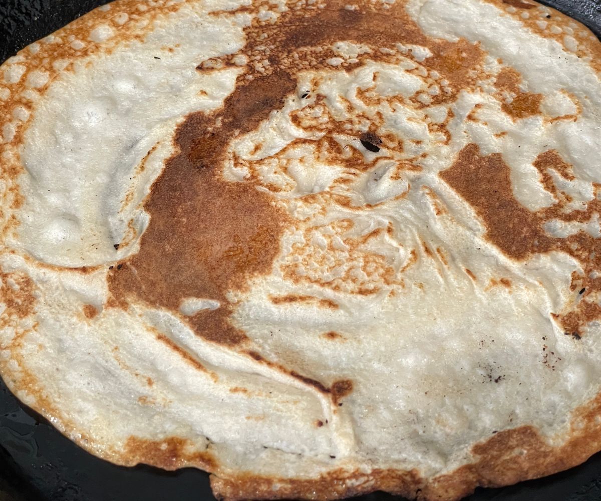 Filliped quinoa dosa on the tawa.