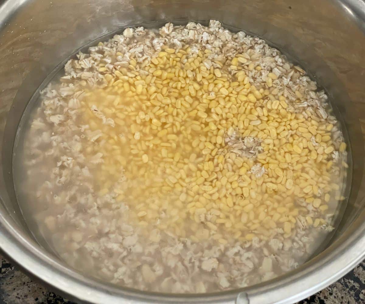 A bowl is filled with water and quinoa and lentils.