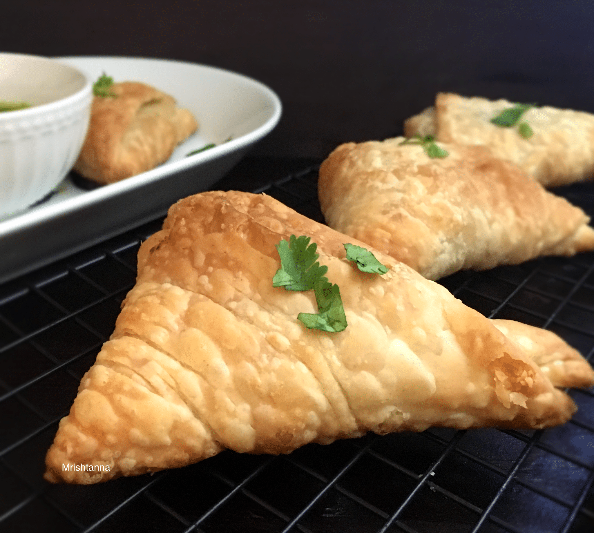 A plate of food on a grill, with Samosa