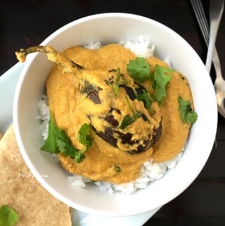 A plate of food on a table, with Curry and Eggplant