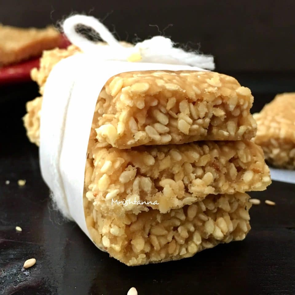 sesame chikki is stacked on the table