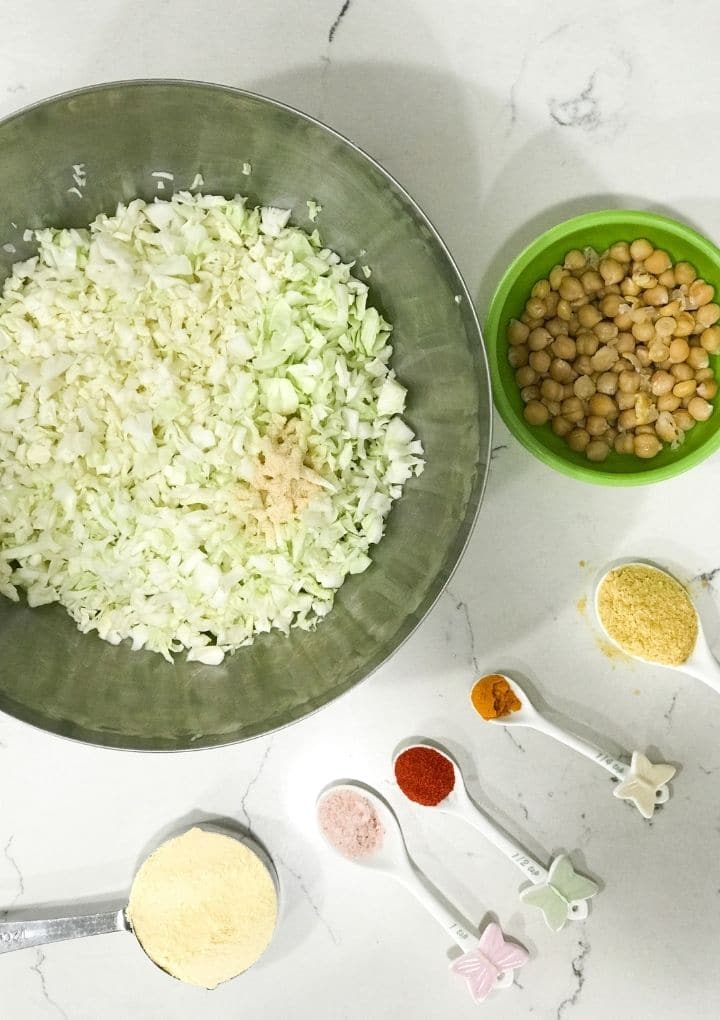 In a big bowl shredded cabbage and other ingredients for cabbage kofta