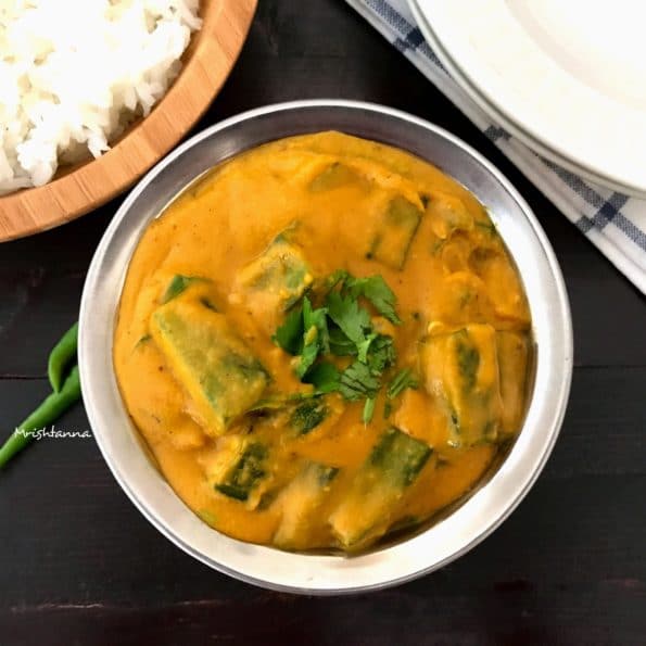 A bowl of bhindi masala is on the black table