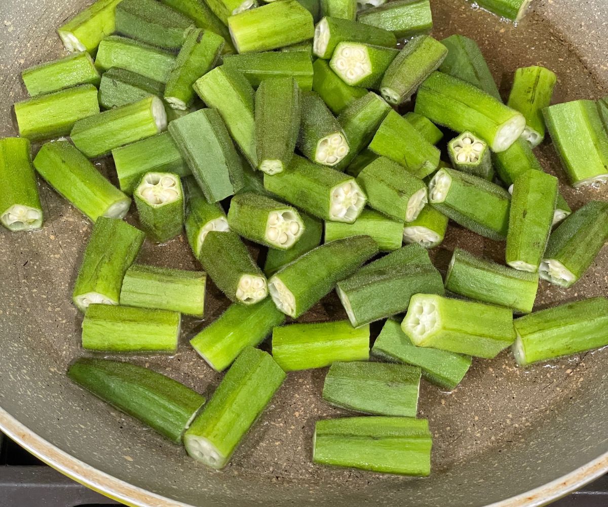 A pan is with oil and okra over the heat.