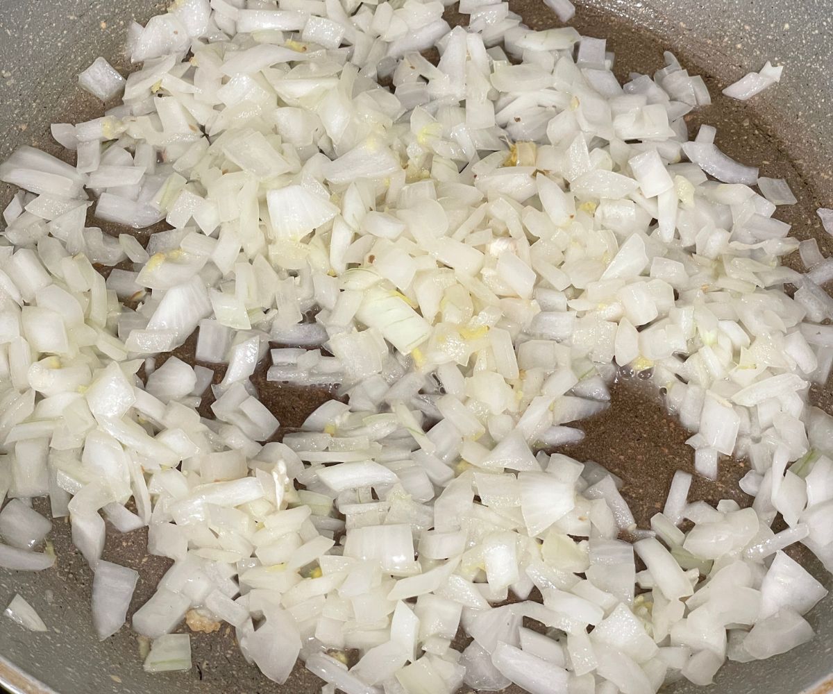 A pan is with chopped onions and oil over the heat.