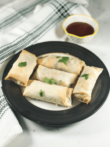 Baked Spring Rolls placed on the black plate