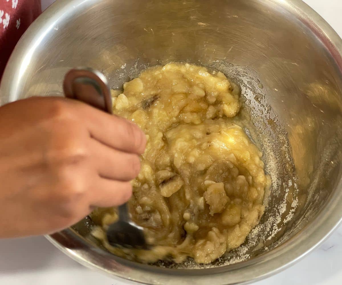A bowl is with mashed bananas and sugar.
