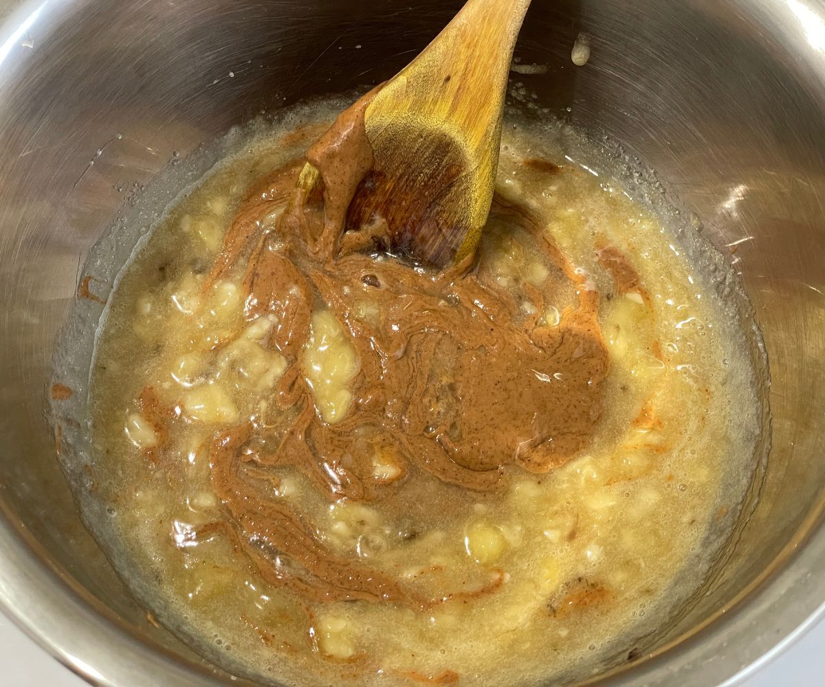 A bowl is with wet ingredients for almond butter muffins.