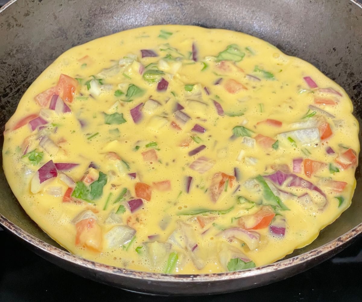A pan is with veg omelet over the heat.