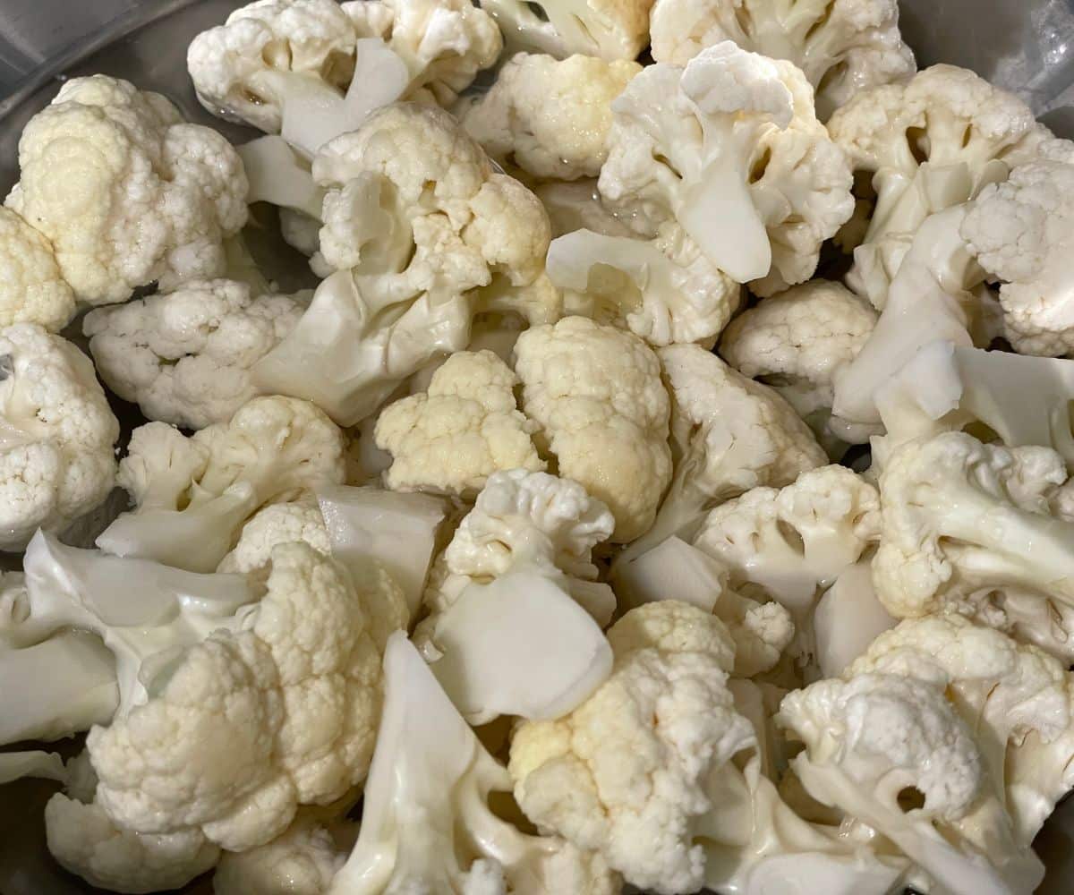 A bowl is with water and cauliflower florets.