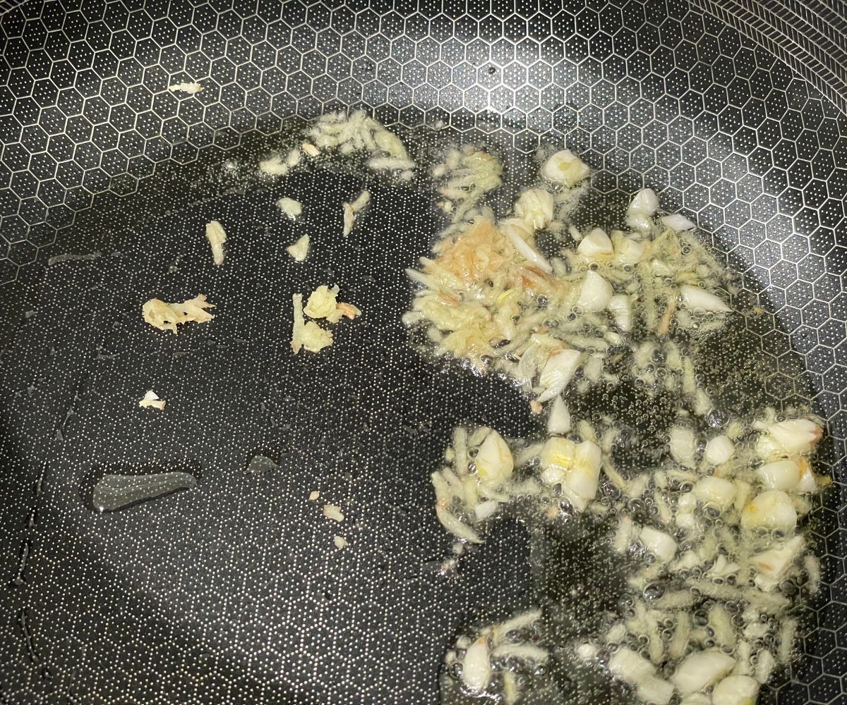 A pan is with ginger and garlic over the heat.