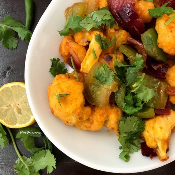 A plate of food, with Cauliflower and Hot sauce