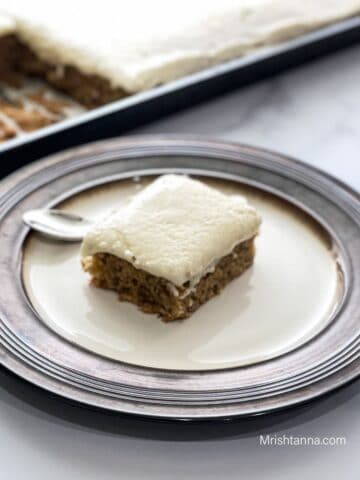 A plate is with sliced vegan banana cake and spoon on the table.