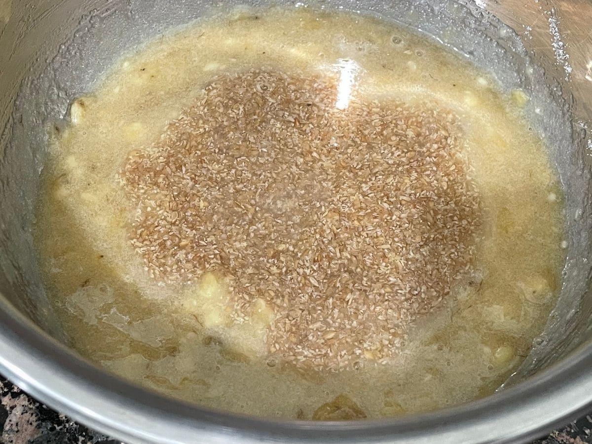 A bowl is with mashed bananas and flax eggs for banana cake