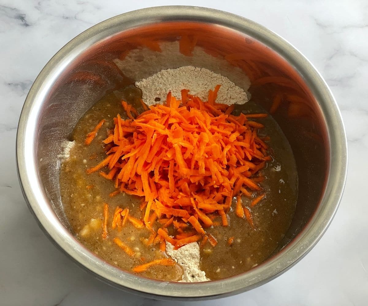 A bowl is with banana carrot muffins batter.