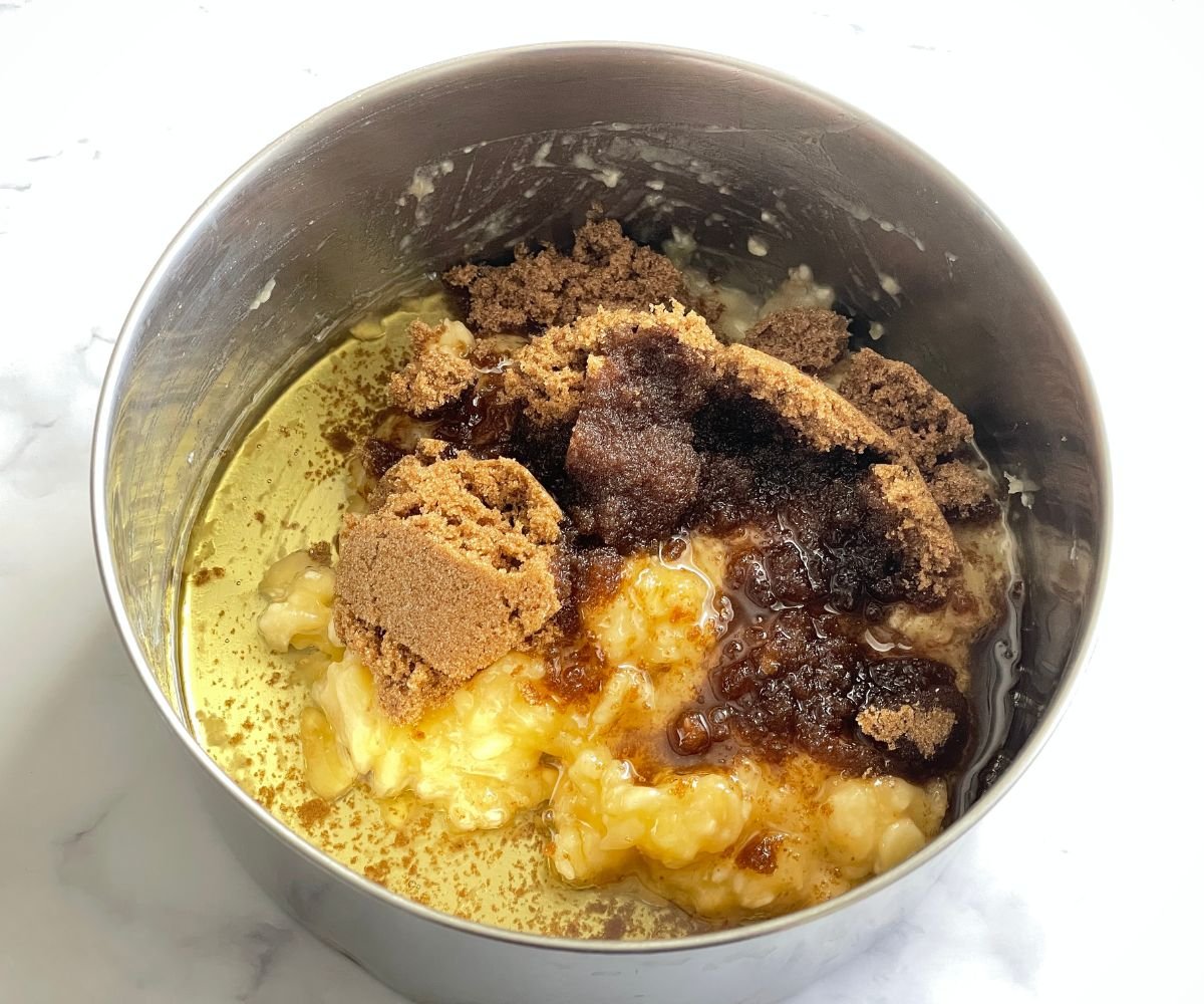 A vessel is with mashed banana and brown sugar.