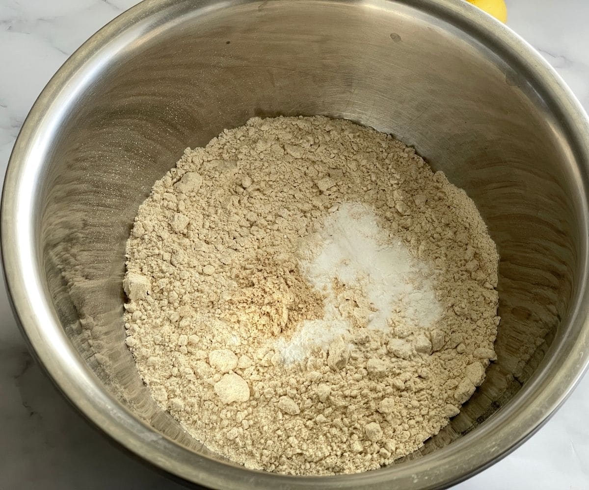 A bowl is with wheat flour, baking soda and baking powder.