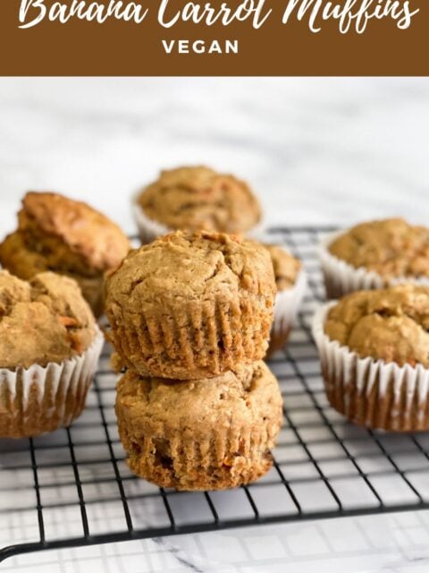 Stacked carrot muffins are on the wire rack.