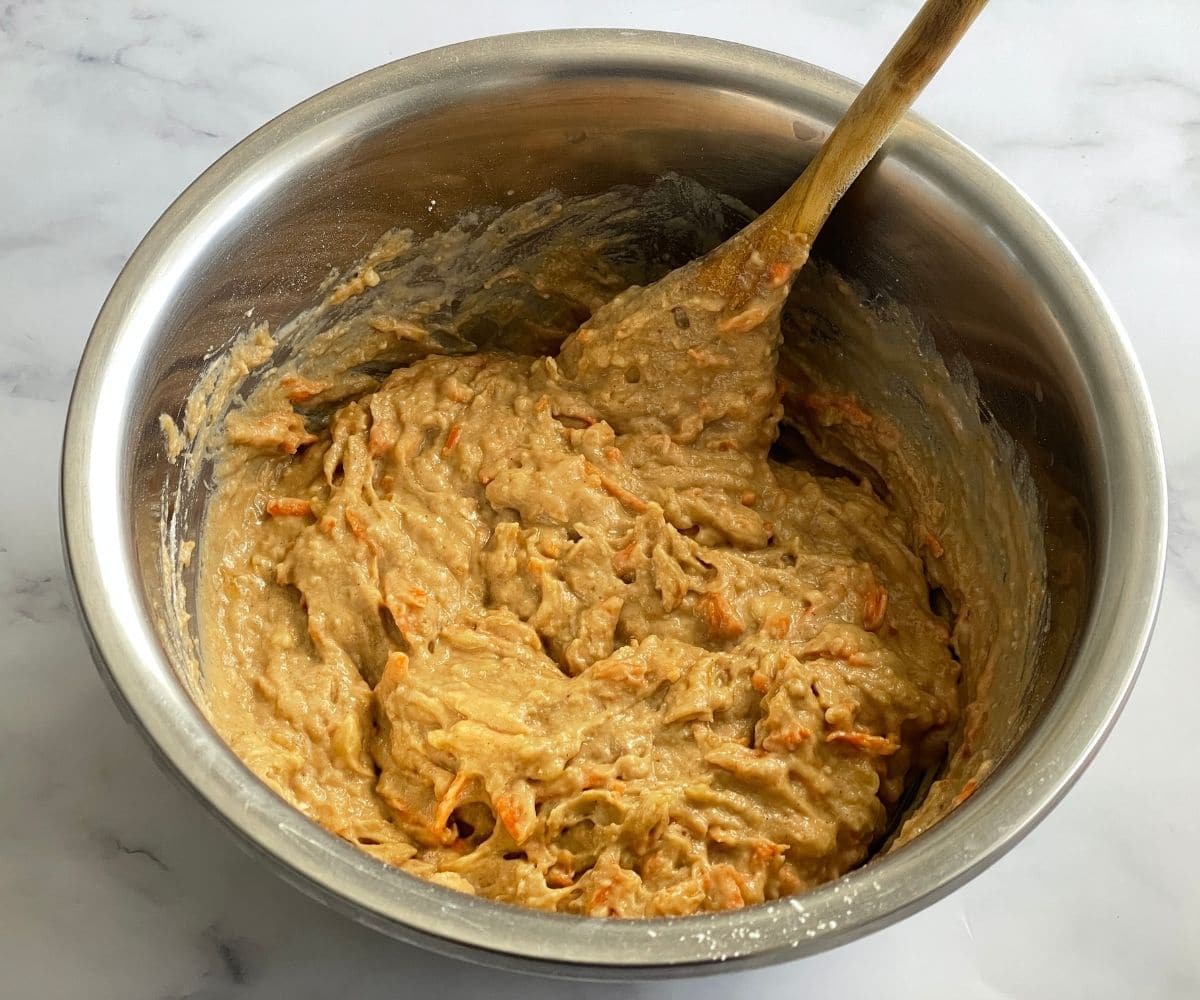 A bowl of banana muffin batter is on the table.