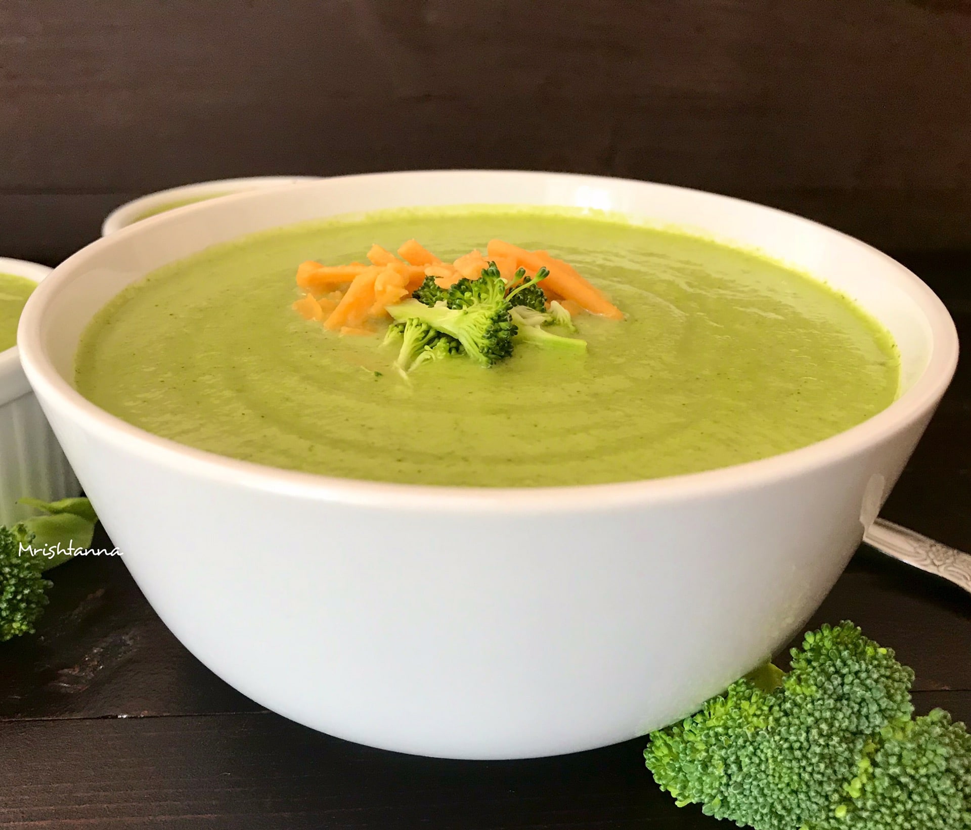 A bowl of broccoli soup and broccoli on a plate