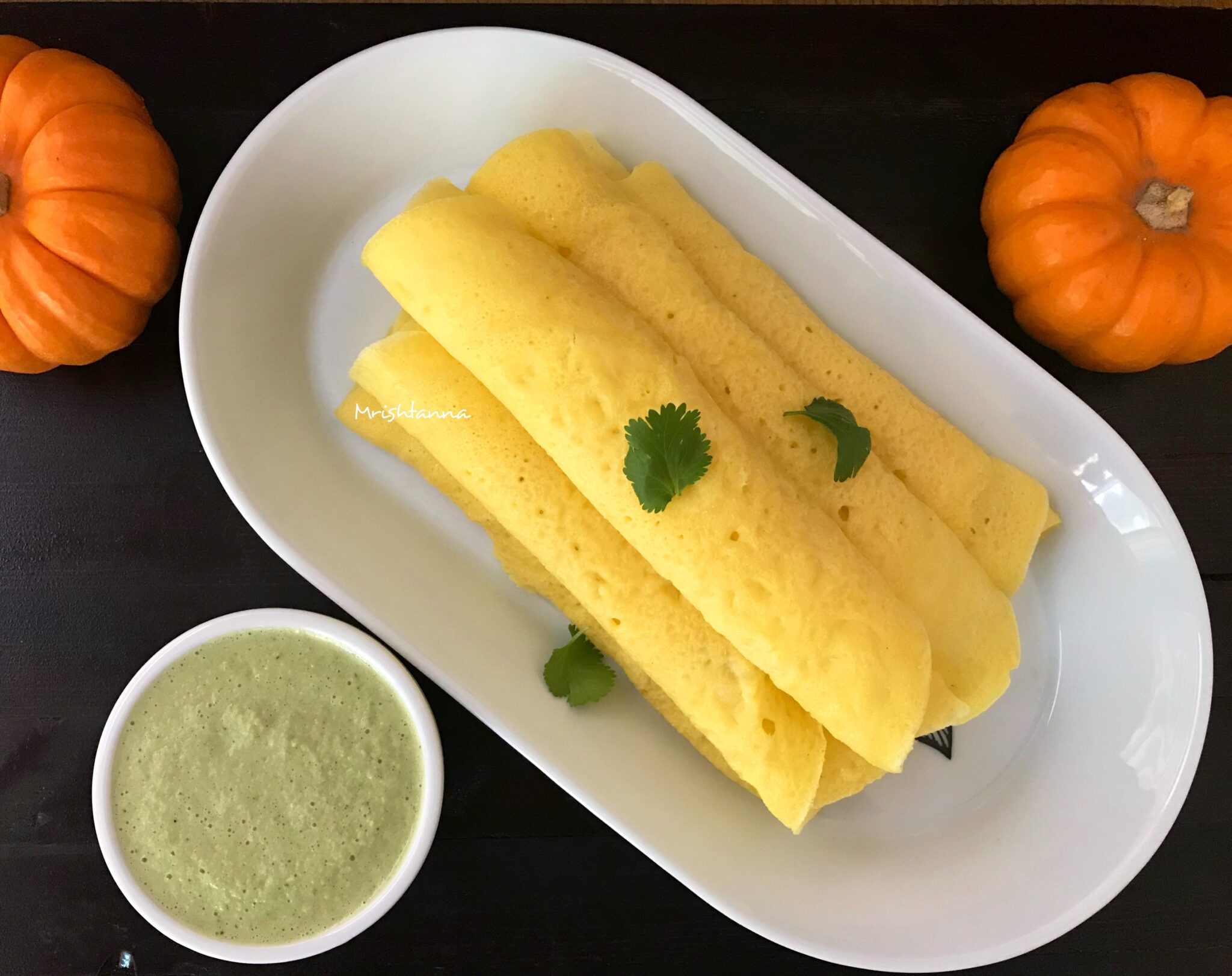 A plate of food on a table, with Pumpkin and Dosa