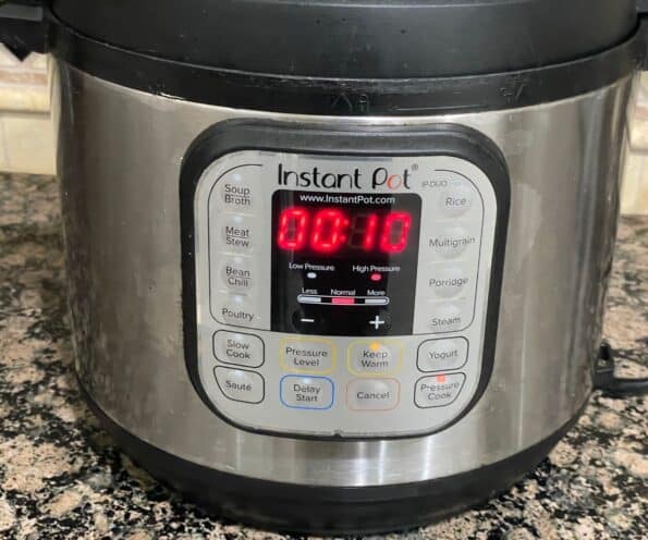 An instant pot showing cooking sign.