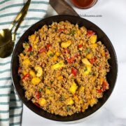 A plate of pineapple fried quinoa is on the table.