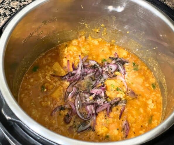 Instant pot is with pumpkin dal and topped with fried onions.