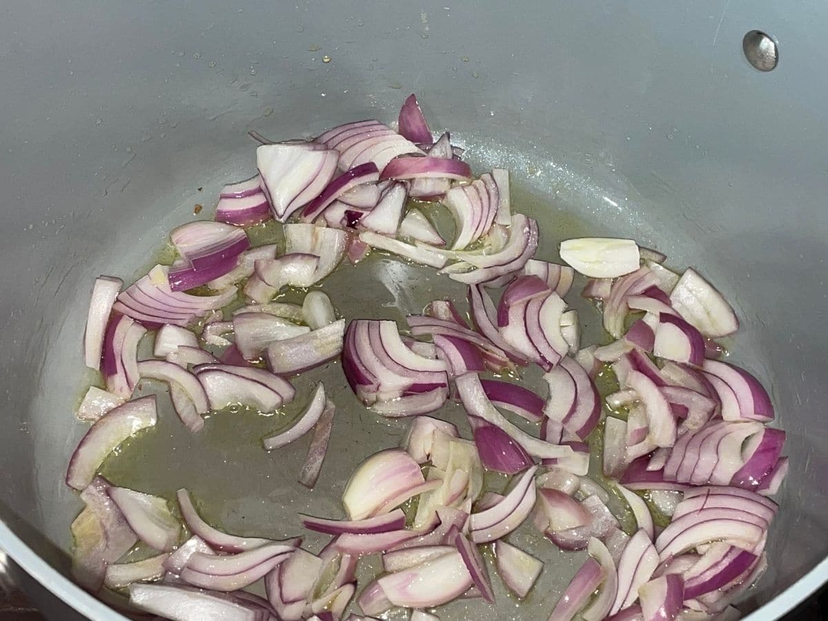 A pan is with oil and chopped onions over the heat.