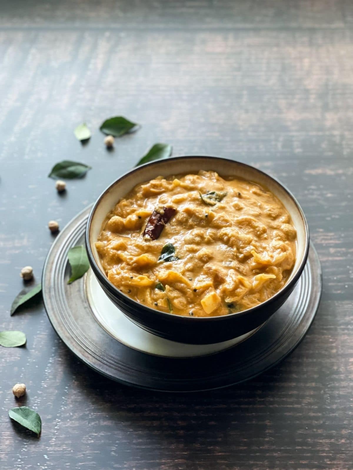 A bowl of gassi is on the table topped with tempering