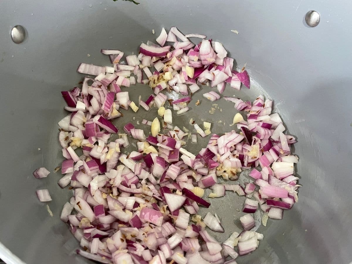 A pan is filled with sauteed onions and garlic 