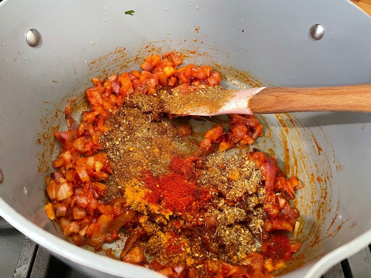 A pan is with masalas for palak tofu curry