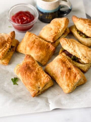 veg puff's are on the round baking tray with sauce.