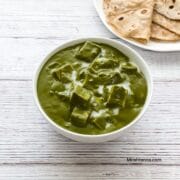 A bowl is with palak tofu gravy on the table.