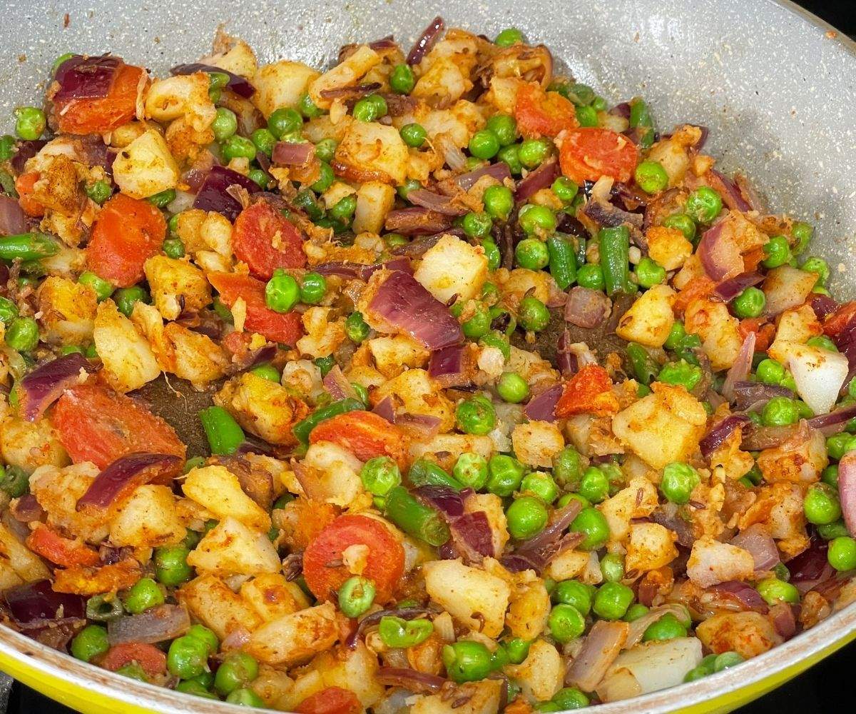 A pan is with vegetable stuffing over the heat.