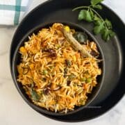 A bowl of Vegan dum biryani is on the plate.