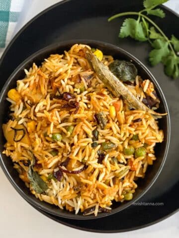 A bowl of Vegan dum biryani is on the plate.