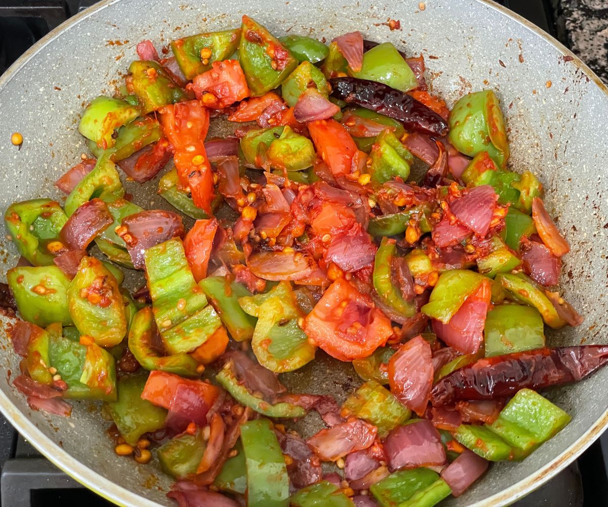 A pan is with capsicum chutney mixture over the heat.