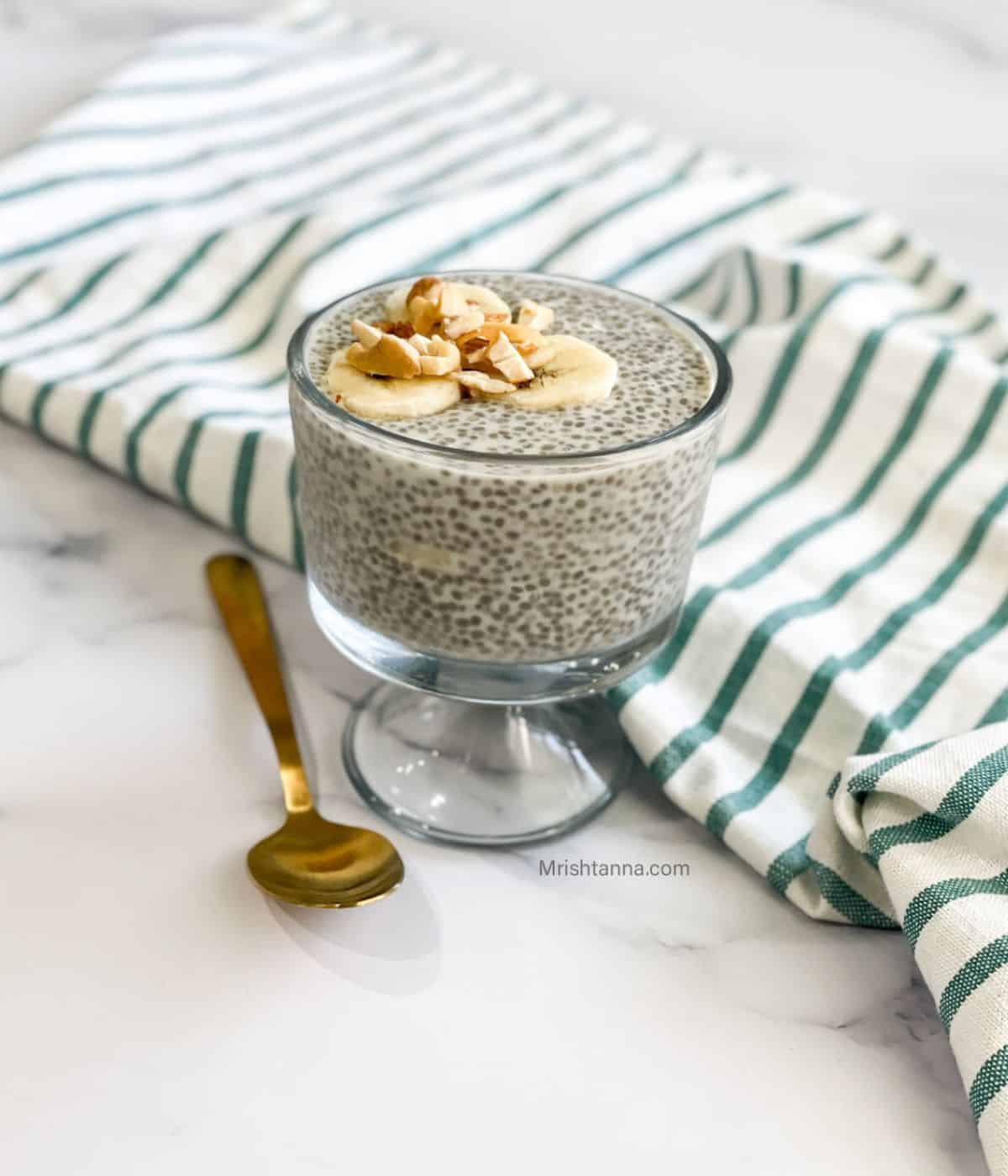 A tall glass is with chia pudding with oat milk.