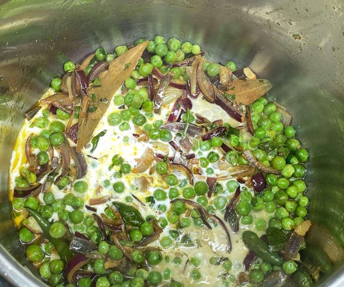 Green peas and sliced onions sautéed with spices and coconut milk in the Instant Pot for pea pulao.