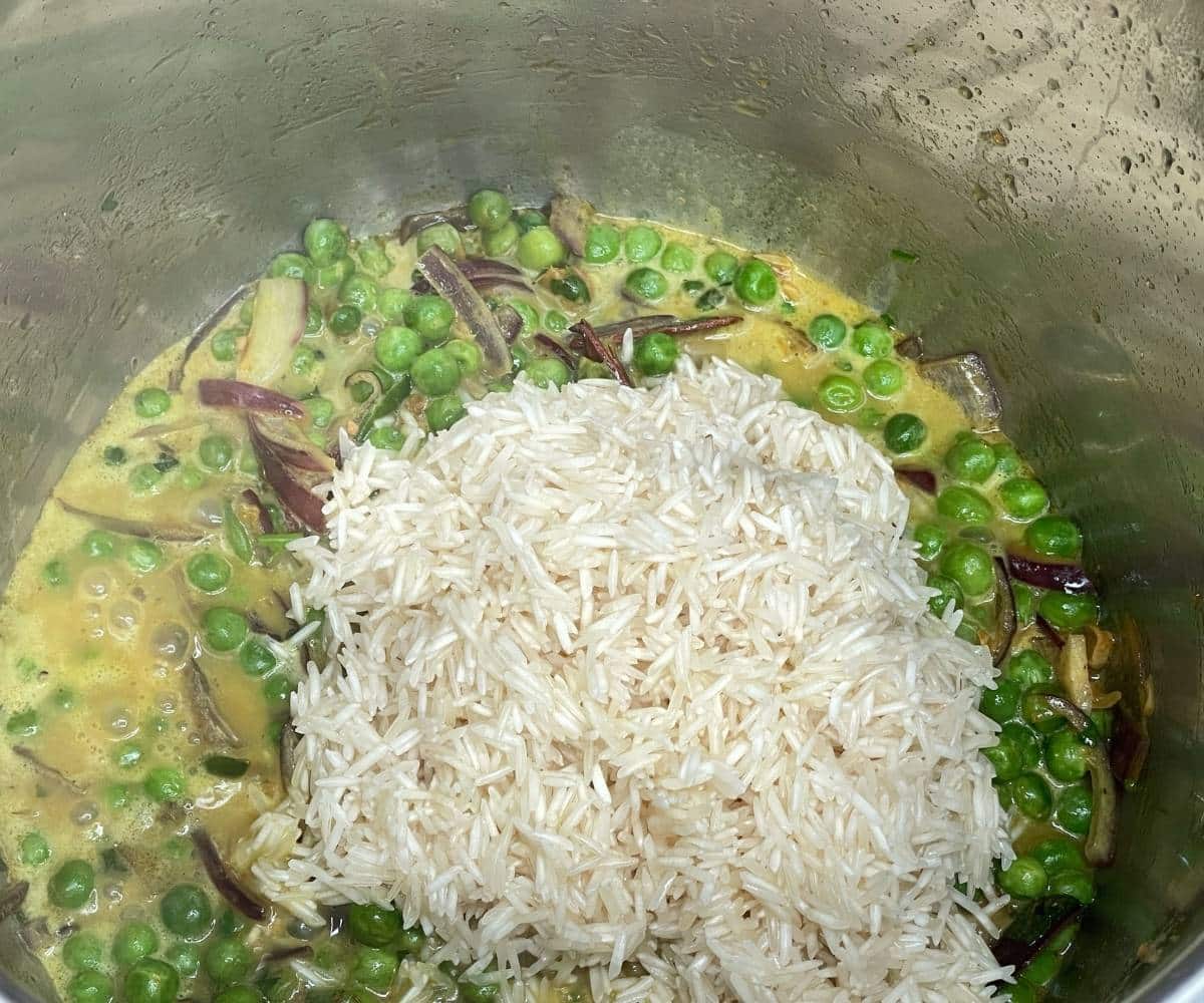 An instant pot filled with peas pulao ingredients.